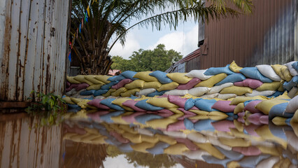 Many sandbags are stacked and reflected in the water.