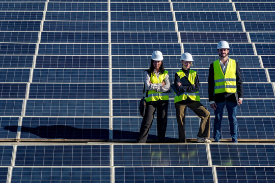 Renewable energy engineers standing with solar panels