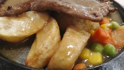 Photo of roast beef, potatoes and vegetables in a baking dish