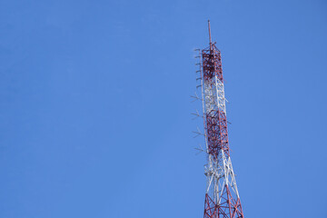 Top of Red and White Signal Tower with Clear Blue Sky Background