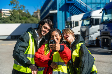 Diverse logistics workers taking selfie at truck depot