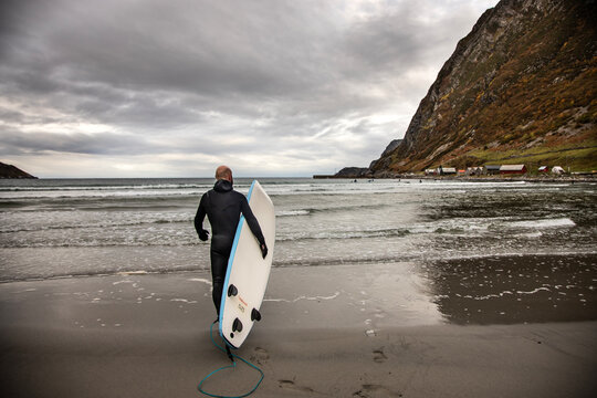 Arctic surfer in Hoddevika Norway