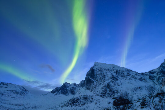 Aurora Borealis. Northern lights and starry sky. Nature on the north. Scandinavian countries. Snow and ice on the mountains. Landscape in winter time. Background, wallpaper, postcard. - Powered by Adobe