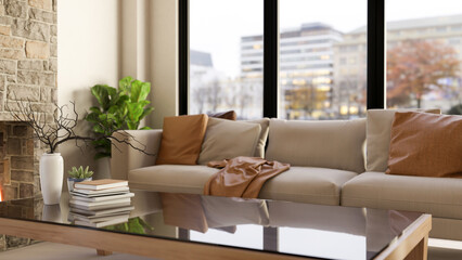 Books and vase on glass table and sofa couch aside fireplace and wall window in a house or apartment