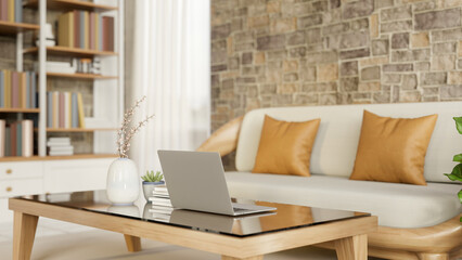 Laptop on glass top wooden table and sofa couch aside bookshelf and bricks wall in a modern house. © bongkarn