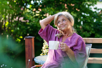 Quiet morning in garden for older woman. Self ritual with coffee.