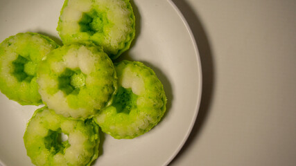 Close-up of a traditional Indonesian cake called putu ayu, a sweet, fragrant cake topped with...