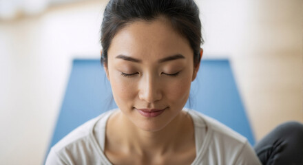 Close-up of a young Asian woman meditating with her eyes closed. Practicing mindfulness and yoga for wellness and mental health