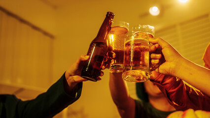 Close up friends hands clinking beer glasses in warm golden light, celebrating friendship teamwork. A joyful moment filled with laughter, unity, positive energy during relaxing evening gathering.