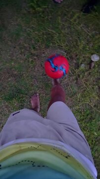 POV of Man Juggling a Red Soccer Ball Outdoors