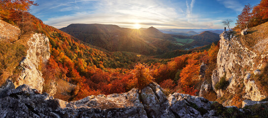 Scenic landscape Slovakia, on beautiful autumn sunrise with colorful leaves on trees in forest and bizarre pointy rocks on mountains valleys.