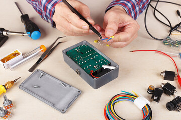 Master servicing electrical components at service workplace.