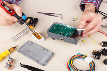 Master solder electrical board at service workplace.