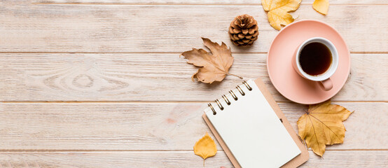 Autumn composition: fallen leaves and craft sketchbook mock up on colored background. Top view. Flat lay with copy space