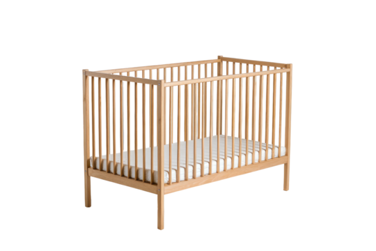 Wooden crib with mattress against a black backdrop