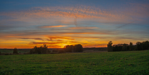 Spectacular sunset over an autumn meadow panorama