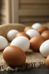 Many raw chicken eggs on grey table, closeup