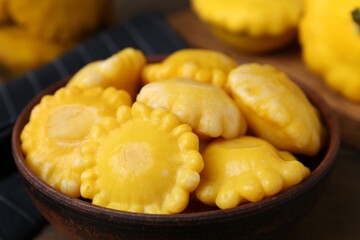 Pickled pattypan squashes in bowl on table, closeup