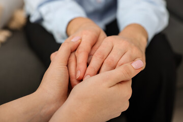 Psychologist supporting woman during therapy session indoors, closeup