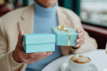 Man holding gift box in cafe setting
