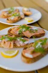 Summer outdoor reception, salmon toast with dill and dill sauce, eating starters in sun