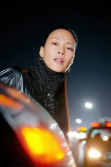 Woman looking out from car window at night