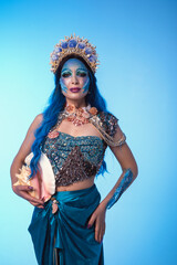 Attractive woman in a blue mermaid costume. Fantasy studio portrait of a mermaid model