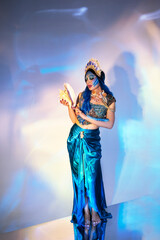 Attractive woman in a blue mermaid costume. Fantasy studio portrait of a mermaid model