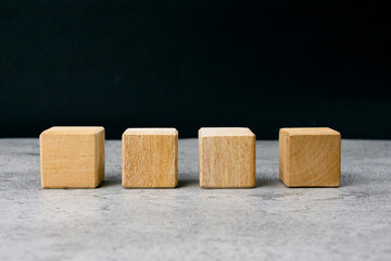 Four empty wooden blocks on a table with empty space for your text, letters or numbers.