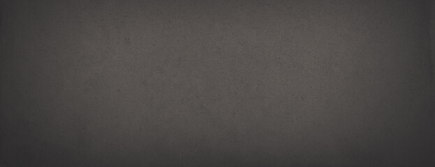 Dark wide panoramic background. Old fade paper texture. Dark panorama with empty space. Rough faded surface. Spots and grain. Blank vintage background for design. Shaded retro texture with vignette.