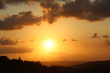 vibrant orange sunset over a distant city skyline. Stunning landscape view of a fiery orange sky