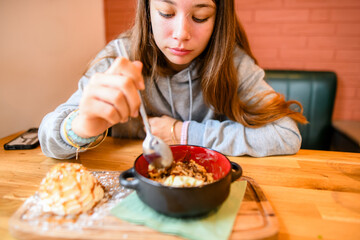 Young girl enjoying homemade cr&egrave;me br&ucirc;l&eacute;e with a scoop of ice cream and whipped cream
