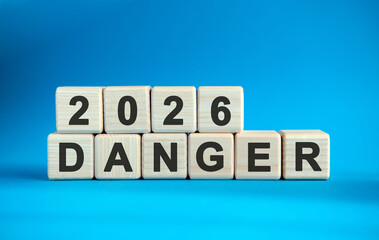 New year Danger 2026 concept. Wooden cubes on a blue background
