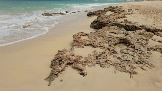 Atlantic Ocean waves breaking over a volcanic rock shoreline of the Cape Verde island of Boa Vista.