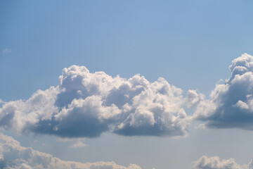 Fluffy white clouds adorn a bright blue sky, enhancing the atmosphere for everyone