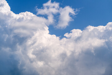 Fluffy white clouds drift gracefully in a bright blue sky, ideal for an artistic backdrop