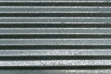 Horizontally corrugated galvanized sheet metal. The texture and grain are clearly visible.