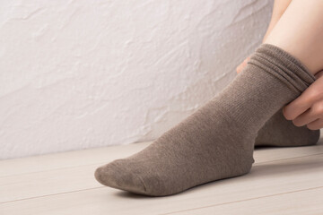  A woman putting on socks. 靴下を履く女性