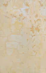 Old cracked wall with peeling paint and faded stains. Vintage beige plaster surface texture with weathered and aged details. Perfect grunge background for design, construction, or retro concept.