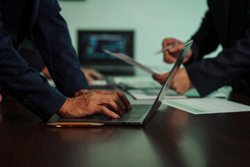 Business professionals closely review a balance sheet and digital Global Investment Portfolio data,...