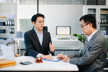 Lawyer advising client on contract signing in modern office, with gavel and scales of justice. Perfect for law, finance, consulting, or business concepts.