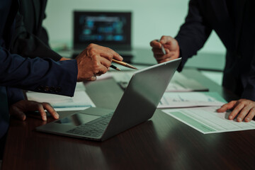 Business professionals closely review a balance sheet and digital Global Investment Portfolio data, pointing to key figures, indicating strategic financial planning and rigorous cash flow management. © Thitaporn