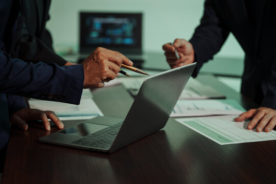 Business professionals closely review a balance sheet and digital Global Investment Portfolio data, pointing to key figures, indicating strategic financial planning and rigorous cash flow management.