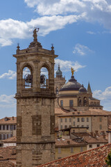 Obraz premium In a vertical view of Bergamo skyline, all main towers rise one behind another, from ancient stone bell tower to cathedral dome and spires