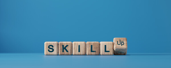 Skill up concept with wooden cubes forming the word SKILL UP on blue background. Learning, training, self development, education, and career growth motivation idea.