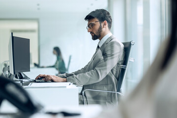 Businessman working at computer in modern office startup environment