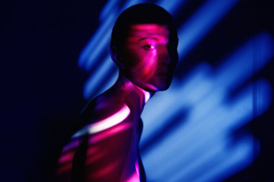 Surreal portrait with neon magenta and blue light effects