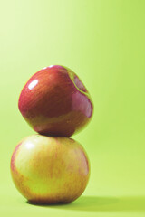 Close up, stacked apple, various colors on a green background.	