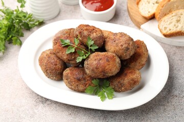 Tasty meat patties served on grey table, closeup