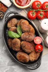 Tasty meat patties served on grey textured table, flat lay